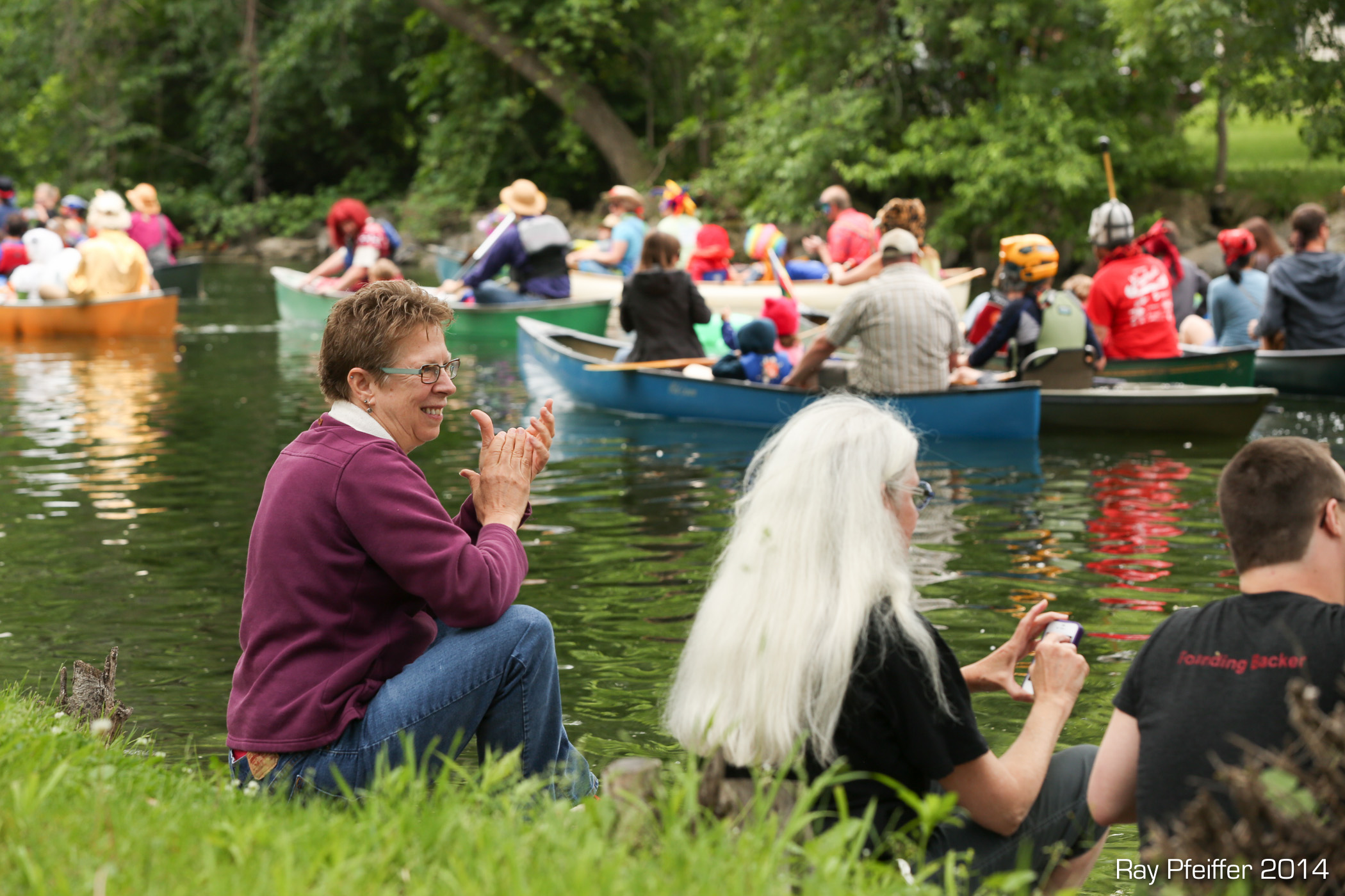 Spectators on the Yahara River banks clapping